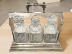 An EPNS three bottle Tantalus, width 40 cm.