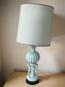 A 19th century turquoise glazed ceramic lamp base, decorated with two cherubs,