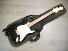 An Encore Stratocaster-style electric guitar, with carry bag.