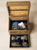 A beech jewellery box containing assorted costume jewellery, gold plated necklaces and brooches,