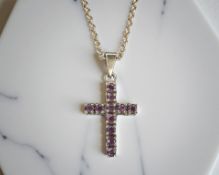 A 9ct yellow gold crucifix pendant set with rubies suspended on 9ct yellow gold chain,