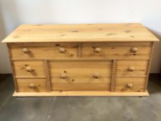 A modern pine seven drawer low chest, 112 cm x 42 cm x 53 cm.
