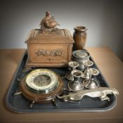 A carved and stained wooden cigarette dispenser decorated with grouse, a ship's wheel barometer,
