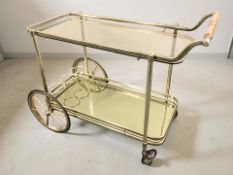 A gilt metal and smoked glass drinks trolley, length 92 cm.