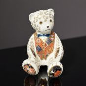 A Royal Crown Derby porcelain seated Teddy bear paperweight, with silver stopper.