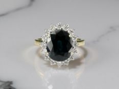An 18ct yellow gold sapphire and diamond cluster ring, size M.