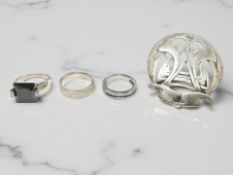 A silver and black onyx ring, another silver ring, a steel ring channel-set with black stones,
