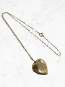 A heart shaped locket with 9ct yellow gold front and back suspended on 9ct yellow gold chain,
