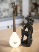 An eastern carved hardwood figure of a fisherman, height 49 cm, together with a stringed instrument.