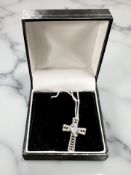 A 925 silver crucifix with black and white stones on chain.