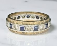 A 9ct two tone gold eternity ring set with synthetic stones, size L.