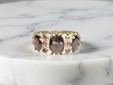 A 9ct yellow gold three stone garnet ring, size N CONDITION REPORT: 5.