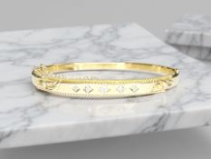 An antique yellow metal bangle set with five small diamonds, 62 mm x 52 mm.