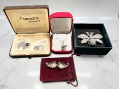 A silver Fuchsia pendant on box link chain and two further white metal costume pendants,