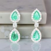 An impressive pair of 18ct white gold emerald and diamond cluster pear shaped drop earrings