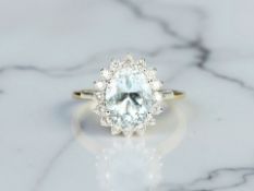 An 18ct white gold aquamarine and diamond cluster ring, size M. CONDITION REPORT: 3.