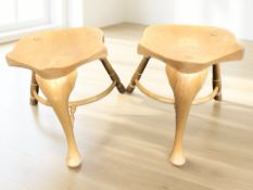 A pair of elm saddle stools with crinoline under stretchers, width 51 cm.