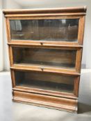 An Edwardian oak three height stacking bookcase in the style of Globe Wernicke,