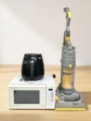 A Dyson vacuum cleaner, a microwave and an air fryer.