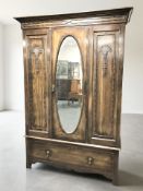 An Edwardian oak three piece bedroom suite comprising mirrored door wardrobe,