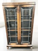 An Edwardian oak and leaded glass double door bookcase, width 83 cm.