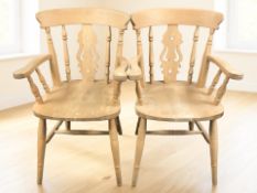 A pair of 20th century pine farmhouse-style spindleback armchairs, width 57 cm.