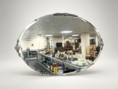 An Art Deco frameless mirror with chrome mounts, width 74 cm.