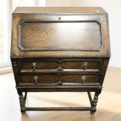 An Edwardian oak fall-front bureau on barley twist supports, 77 cm x 41 cm x 97 cm.