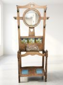 An Arts & Crafts oak tiled back hall stand, 87 cm x 33 cm x 185 cm.