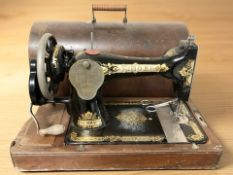 A Singer hand sewing machine, in case.