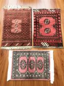 Three Bokhara rugs, each approximately 83 cm x 54 cm.