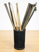 A plastic bin containing a large quantity of snooker cues, some with metal cases,