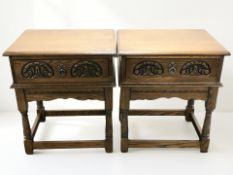 A pair of reproduction carved oak single drawer side tables, width 57 cm.