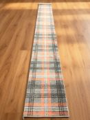 A modern machine-made runner on grey ground, 540 cm x 67 cm.