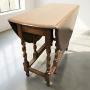 A reproduction oak barley twist drop leaf table, width 92 cm.