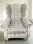A modern wingback armchair in checkered fabric.