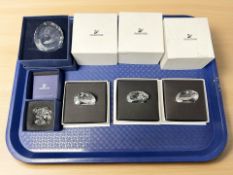 A collection of boxed Swarovski crystal paperweights.