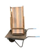 A folding deck chair and a wheel barrow.