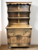 A reproduction carved oak dresser, 93 cm x 48 cm x 173 cm.