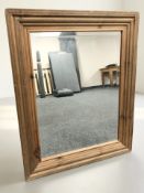 A contemporary pine framed bevelled mirror, 77 cm x 61 cm.