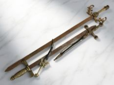 A group of decorative daggers and swords with brass hilts