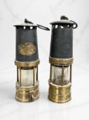 A brass and blackened steel miner's safety lamp, with maker's plaque 'J H Naylor, Wigan',