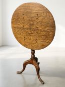 A George III oak circular tilt top tripod occasional table, height 74 cm.