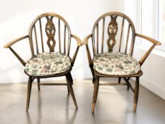 A pair of 20th century Ercol stained elm fleur de lys spindle back chairs, width 60 cm.