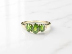 A 9ct yellow gold ring set with green stones and four diamonds, size O 1/2.