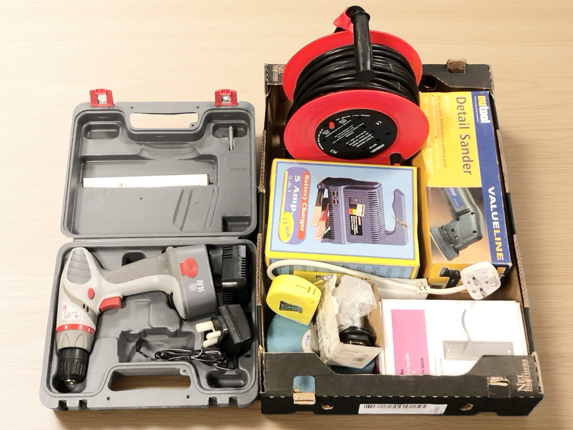 A cordless electric drill in case, an extension lead,
