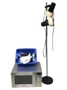 A Tower stainless steel microwave, a small standard lamp, and a small box of household electricals.