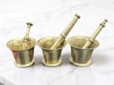 Three 18th / 19th century bronze bell mortars with pestles, tallest mortar 12 cm.