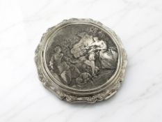 A Stratton compact with embossed panel depicting figures in a garden.