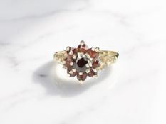 A 9ct gold ring set with a garnet cluster, size O. CONDITION REPORT: 2.2g.